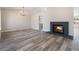 Spacious living room boasts wood-look floors, a brick fireplace, and plenty of natural light for a cozy atmosphere at 8000 Vista Twilight Dr, Las Vegas, NV 89123
