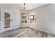 Bright living room featuring wood floors, a modern light fixture, and a door leading to the backyard at 8000 Vista Twilight Dr, Las Vegas, NV 89123