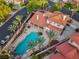 Stunning aerial view of home with a private pool, red tile roof, well manicured yard and towering palm trees at 8104 Wispy Sage Way, Las Vegas, NV 89149