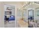 Bright bathroom with a stone sink, large mirror, and doorway to bedroom at 8104 Wispy Sage Way, Las Vegas, NV 89149