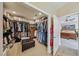 Spacious walk-in closet with custom shelving, rod space, a center dresser and an ottoman at 8104 Wispy Sage Way, Las Vegas, NV 89149