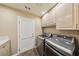 Bright laundry room features a door, cabinets and modern, front loading washer and dryer at 8104 Wispy Sage Way, Las Vegas, NV 89149