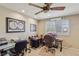 Bright office area with a ceiling fan, two desks, and a window with plantation shutters at 8104 Wispy Sage Way, Las Vegas, NV 89149