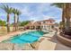 Beautiful pool with rock accents, palm trees, and a spacious backyard for relaxation and entertainment at 8104 Wispy Sage Way, Las Vegas, NV 89149