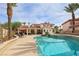 Lush backyard with a sparkling pool, waterfall feature, and well-maintained landscaping at 8104 Wispy Sage Way, Las Vegas, NV 89149