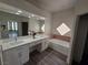 Bathroom featuring double sinks, marble countertop, and a tub with tile accents at 8545 Summer Vista Ave, Las Vegas, NV 89145