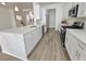 Bright kitchen featuring new stainless-steel appliances, white cabinets, quartz counters, and wood-look floors at 8545 Summer Vista Ave, Las Vegas, NV 89145