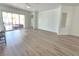 Open-concept living room with sliding glass doors to the patio, wood floors, and light walls at 8545 Summer Vista Ave, Las Vegas, NV 89145