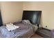 Bedroom featuring a large dark headboard, a gray comforter, and a comfortable pet bed at , Las Vegas, NV 89183