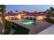 A twilight aerial view of a home with an in-ground pool, a slide and a well-manicured outdoor space at 10280 W La Mancha Ave, Las Vegas, NV 89149