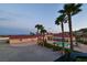 Aerial view of the home featuring a pool, palm trees, and a red tile roof at 10280 W La Mancha Ave, Las Vegas, NV 89149