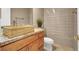 Modern bathroom with wooden vanity, granite countertops, and a tiled shower at 10280 W La Mancha Ave, Las Vegas, NV 89149