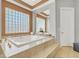Bright main bathroom featuring a jetted tub under a glass block window at 10280 W La Mancha Ave, Las Vegas, NV 89149