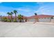 Spacious driveway leading to a home with a red tile roof and multiple garage doors for ample parking at 10280 W La Mancha Ave, Las Vegas, NV 89149