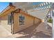 Exterior shot of a tan house featuring a pergola covered patio at 10280 W La Mancha Ave, Las Vegas, NV 89149