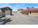 An exterior view of a home with a shed and a garage with ample parking space in the driveway at 10280 W La Mancha Ave, Las Vegas, NV 89149