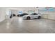 Spacious garage with epoxy floors, multiple overhead doors, and space for cars and motorcycles at 10280 W La Mancha Ave, Las Vegas, NV 89149