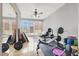 Home gym featuring mirrored wall, ceiling fan, workout bench, and natural light at 10280 W La Mancha Ave, Las Vegas, NV 89149