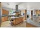 Kitchen with wooden cabinets, granite counters, modern stainless steel appliances, and center island at 10280 W La Mancha Ave, Las Vegas, NV 89149