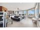 Open concept living room with wet bar, leather couches, tile floors and large windows at 10280 W La Mancha Ave, Las Vegas, NV 89149