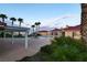 A backyard pool area featuring a water slide, palm trees, and desert landscape at 10280 W La Mancha Ave, Las Vegas, NV 89149