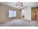 Bedroom featuring carpet, ceiling fan, window, and ensuite bathroom entrance at 10360 Cherry Brook St, Las Vegas, NV 89183