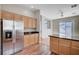Bright kitchen with wooden cabinets, stainless steel refrigerator, and hardwood flooring at 10360 Cherry Brook St, Las Vegas, NV 89183