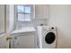 Laundry room with washer, dryer, window, and overhead cabinets at 10360 Cherry Brook St, Las Vegas, NV 89183