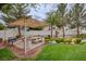 Outdoor picnic area with tables, benches, shade, and barbecue grill surrounded by lush greenery at 10360 Cherry Brook St, Las Vegas, NV 89183