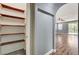 Hallway featuring wood-look floors, an open layout, and storage shelves leading to the living room at 10805 Cain Ave, Las Vegas, NV 89166