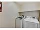 This laundry room includes a modern washer, a modern dryer, and overhead shelving at 10805 Cain Ave, Las Vegas, NV 89166