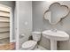 Charming powder room featuring a pedestal sink, decorative mirror, and convenient storage at 10805 Cain Ave, Las Vegas, NV 89166