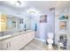 Modern bathroom features marble countertops, dual sinks, a large mirror, and tile floors at 1112 Sandy Cove St, Las Vegas, NV 89110