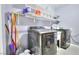 Practical laundry room featuring modern washer and dryer units and storage shelves at 1112 Sandy Cove St, Las Vegas, NV 89110