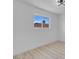 Bright, minimalist bedroom with light wood floors and a window showcasing the clear sky at 1115 W Nelson Ave, North Las Vegas, NV 89030