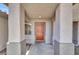 Inviting covered front porch with decorative columns and a bright orange front door at 1225 Stonesthrow Cir, North Las Vegas, NV 89031