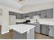Modern kitchen featuring gray cabinets, stainless steel appliances, island, and white quartz countertops at 1225 Stonesthrow Cir, North Las Vegas, NV 89031