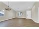 Open living room with wood-look floors, neutral paint, and a white interior door at 1225 Stonesthrow Cir, North Las Vegas, NV 89031