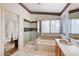 Beautiful bathroom featuring a walk-in glass shower, soaking tub, wood vanity and a window at 1333 Date Palm Cir, Las Vegas, NV 89108