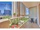 Relaxing balcony with comfortable seating offering views of lush greenery and high-rise buildings at 135 E Harmon Ave # 315, Las Vegas, NV 89109