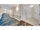 A long hallway with decorative patterned carpeting and three white doors leading to individual residences at 135 E Harmon Ave # 315, Las Vegas, NV 89109