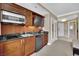 This kitchenette features wood cabinets, stainless steel microwave, cooktop, and a mini fridge, offering convenience and style at 135 E Harmon Ave # 315, Las Vegas, NV 89109