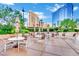 Outdoor patio area with multiple tables and chairs, umbrellas and green landscaping at 135 E Harmon Ave # 315, Las Vegas, NV 89109