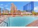 Resort style swimming pool with inviting clear water and palm trees; city view in the background at 135 E Harmon Ave # 315, Las Vegas, NV 89109