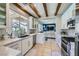 Well-equipped kitchen with white cabinets, stainless steel appliances, and a view to the outdoors at 1701 Drifters Peak St, Las Vegas, NV 89144