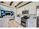 Eat-in kitchen with stainless steel appliances, white cabinets, and a view of the living room at 1701 Drifters Peak St, Las Vegas, NV 89144