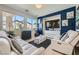 Bright living room with large windows, blue accent wall, and comfortable white couches at 1701 Drifters Peak St, Las Vegas, NV 89144