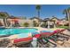 Sparkling pool and lounge chairs, with mature trees and covered seating at 1701 Drifters Peak St, Las Vegas, NV 89144