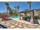 Inviting pool and lounge area with mature desert landscaping and covered seating at 1701 Drifters Peak St, Las Vegas, NV 89144