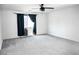 Spacious bedroom features soft carpet, ceiling fan, and large window with blue curtains at 1703 Game Garden Rd, North Las Vegas, NV 89031